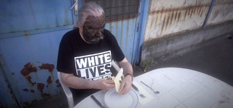 Schuster Lóránt blackface-ben, White Lives Matter pólóban hámozza a banánt